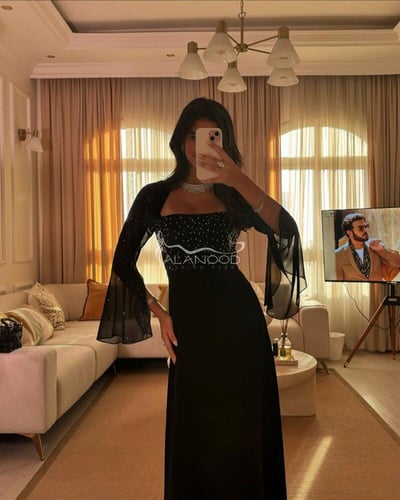 فستان أسود ناعم للأعياد بتصميم متقن
