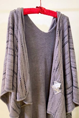 رداء بقبعة مع جيوب وبروش أنيق وعملي.