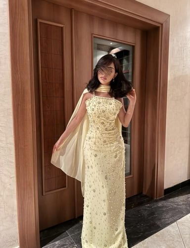 فستان سهرة أصفر مطرز بكريستالات وقصة ضيقة أنيقة