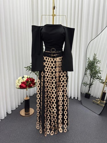 فستان أسود فاخر بتفاصيل سلاسل ذهبية