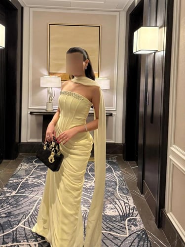 فستان سهرة أصفر فاتح بكسرات جانبية وتطريز كريستالي