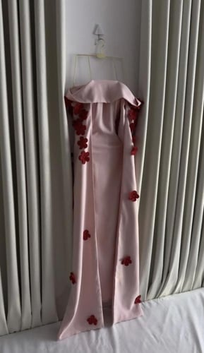 فستان وردي مطرّز بالزهور الحمراء بتصميم أنثوي راقٍ