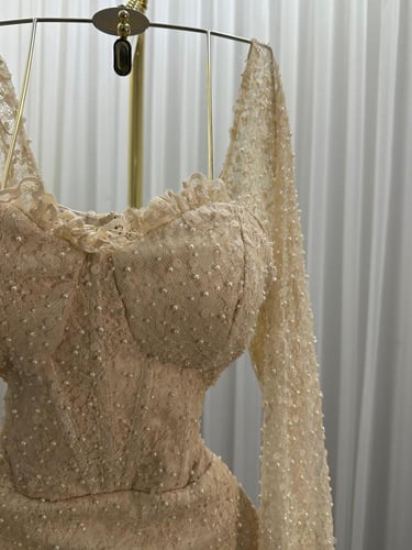 فستان سهرة ذهبي ضيق بترتر لامع وأكمام طويلة شفافة