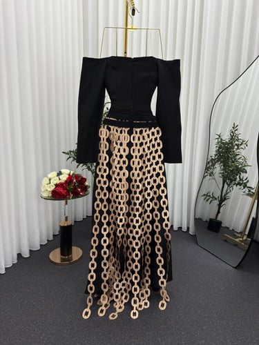 فستان أسود فاخر بتفاصيل سلاسل ذهبية