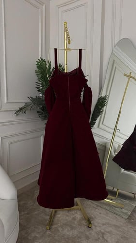 فستان خمري بتفاصيل لؤلؤية وتصميم أكمام درامية