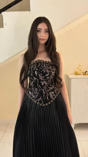 فستان أسود مطرّز بتنورة بليسيه فاخرة