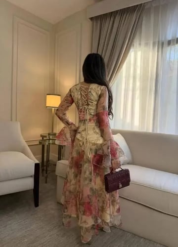 فستان "نرجس" ميدي بطبعات الورود وأكمام كلوش واسعة.