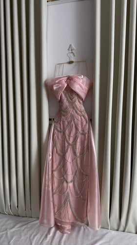 فستان سهرة وردي بعقدة كبيرة وتطريز فاخر