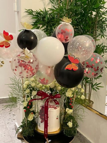 بالونات مزينة بالفراشات مع الورد وكيكة وسط