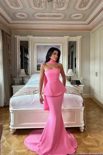 A pink dress with a gathered skirt, a layer at the waist, and a scarf around the neck completes the look with charm and softness.