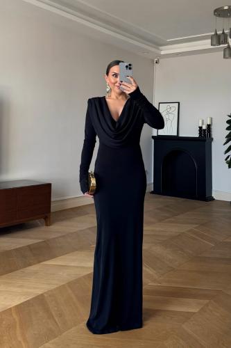 Long black dress with an elegant flowing design, featuring a soft DRAPED neckline and long sleeves, giving a classy and sophistica...