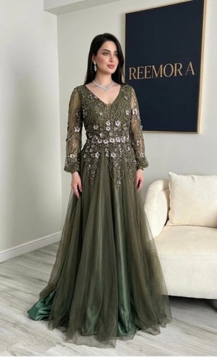 An evening dress in olive green decorated with lux...