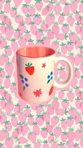 A cup of coffee with a strawberry design hand-draw...