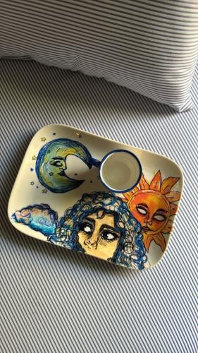 A large plate between the sun and the moon with a...