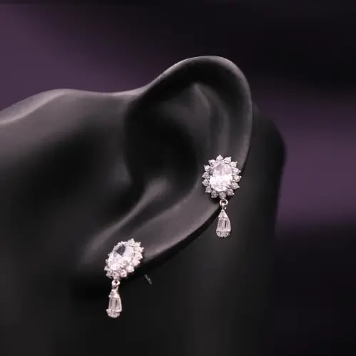 Silver drop earring with a flower design and teard...