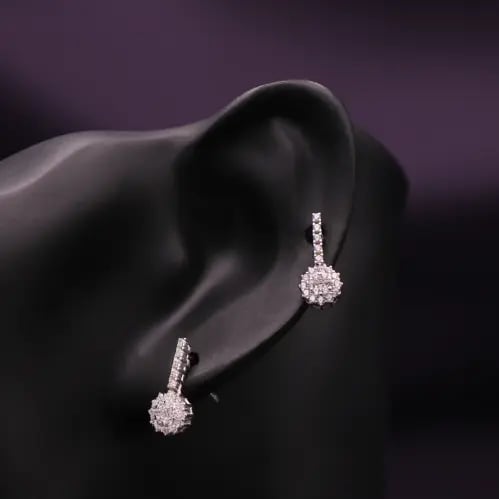 Silver drop earring with a shiny circular pendant,...