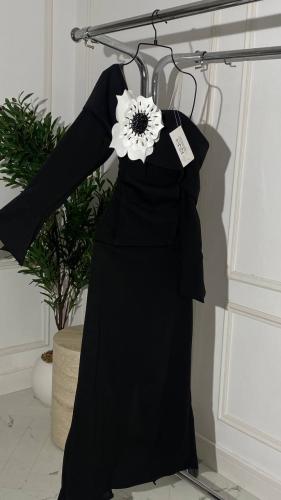 فستان روان أسود أنيق بتفصيلة زهرة بيضاء فاخرة