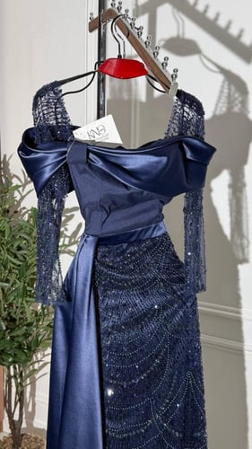 فستان سهرة كحلي داكن تفته بذيل جانبي طويل