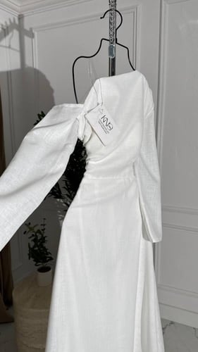 فستان ابيض بأكمام طويله غير متماثله