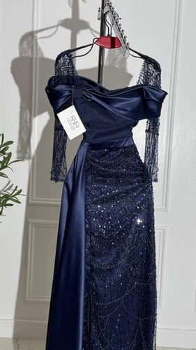 فستان سهرة كحلي داكن تفته بذيل جانبي طويل