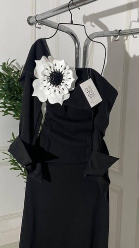 فستان روان أسود أنيق بتفصيلة زهرة بيضاء فاخرة