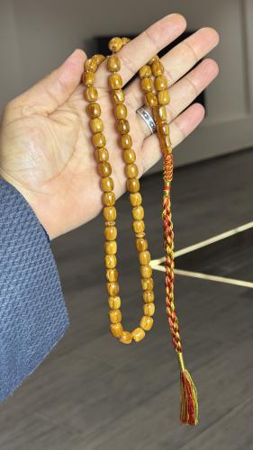 A Tasbih with a leather strap and a decorative pen...