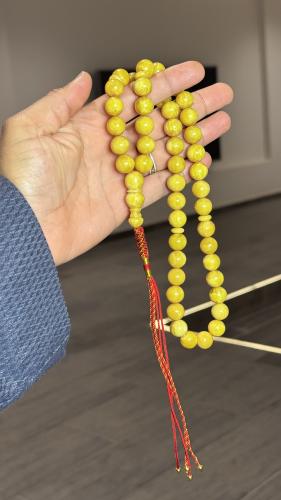 A Tasbih with a leather strap and a decorative pen...