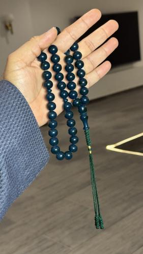 A Tasbih with a leather strap and a decorative pen...