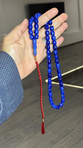 A Tasbih with a leather strap and a decorative pen...