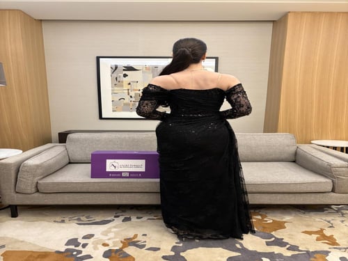 فستان سهرة دانتيل أسود بكتف منسدل وذيل جانبي.