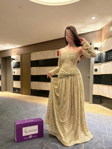 فستان سهرة طويل بلون الذهبي اللامع بأكمام طويلة وم...