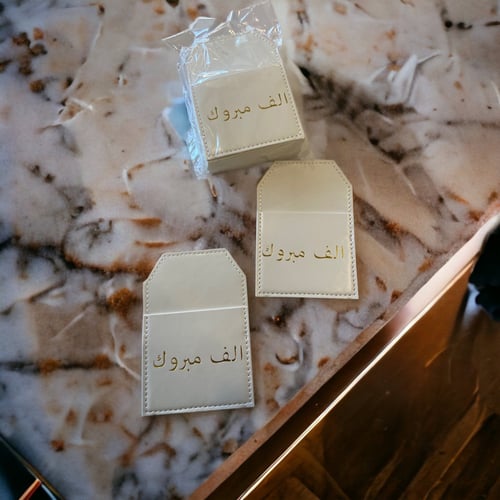 جيوب جلد أبيض بعبارة ألف مبروك12 حبه.