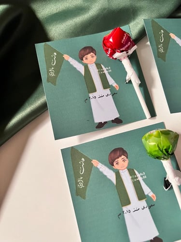 توزيعات اطفال حلاوه مصاص مع ثيم اليوم الوطني