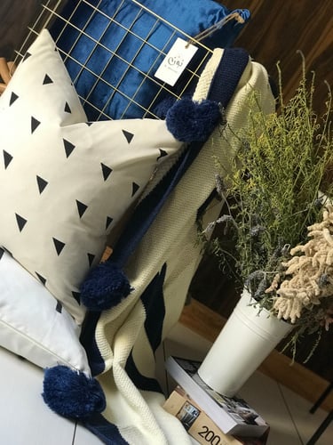 بطانية كريمي وأزرق محبوكة مزينة بكور البوم بوم