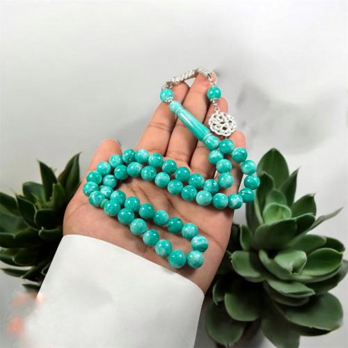 A prayer bead with a brass tab design, metal
