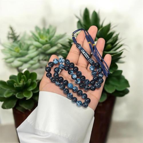 A prayer bead with a clasp, decorated with a Karko...