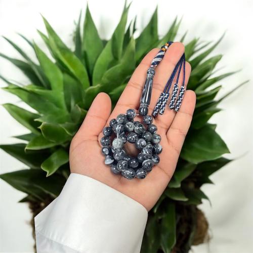 A prayer bead with a clasp, decorated with a Karko...