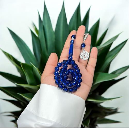 A prayer bead with a brass tab design, metal