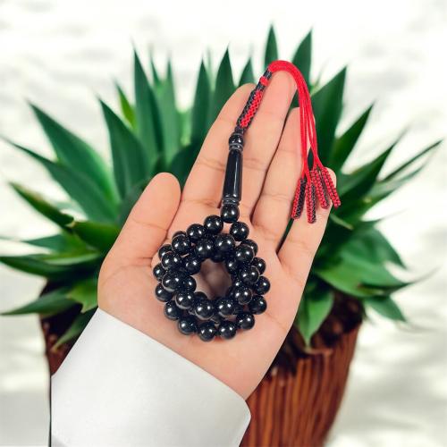 A prayer bead with a clasp, decorated with a Karko...