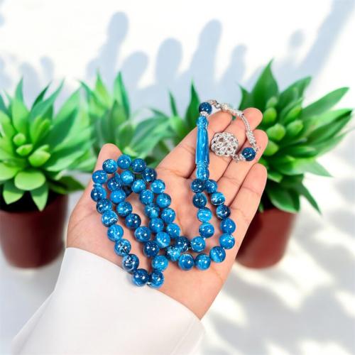 A prayer bead with a brass tab design, metal