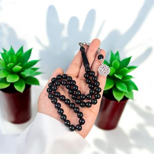 A prayer bead with a brass tab design, metal