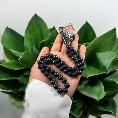 A prayer bead with a brass tab design, metal