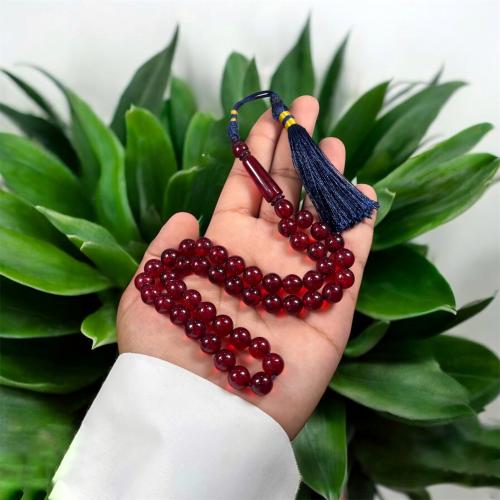 A prayer bead with a clasp, decorated with a Karko...
