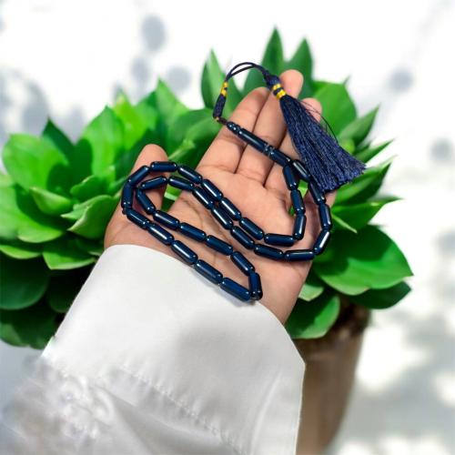 A prayer bead with a clasp, decorated with a Karko...