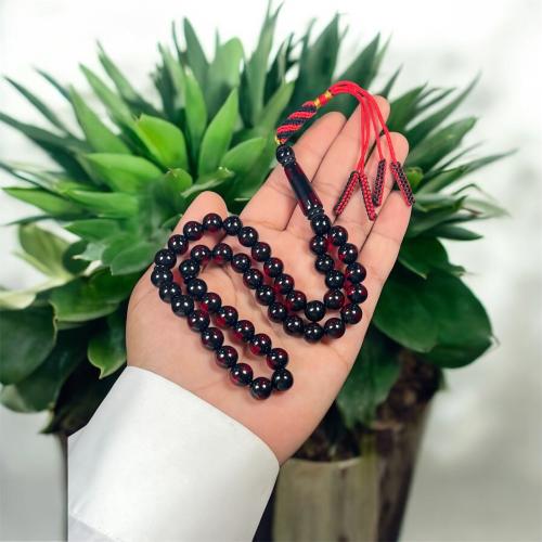 A prayer bead with a clasp, decorated with a Karko...