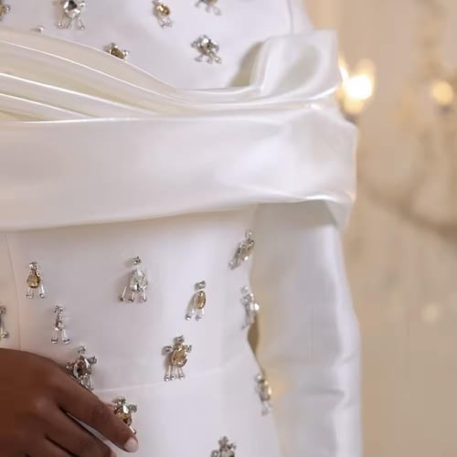 فستان محتشم مزين بالكرستالات وذيل طويل