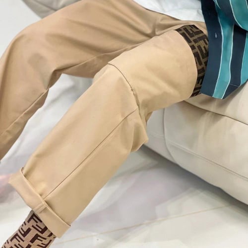 بنطلون بيج من قماش الجبردين عليه شعار للماركة