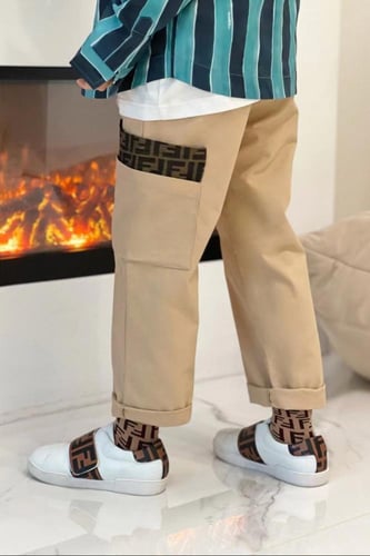 بنطلون بيج من قماش الجبردين عليه شعار للماركة