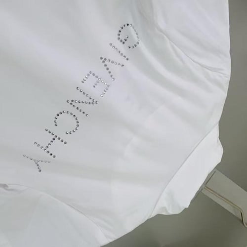 فستان ابيض بسحاب امامي وشعار سوارفسكي للماركة جيفن...