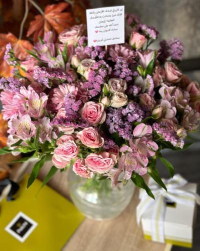 تنسيق ورد بيبي روز بالأغصان في فازة مع علبة شوكولا...